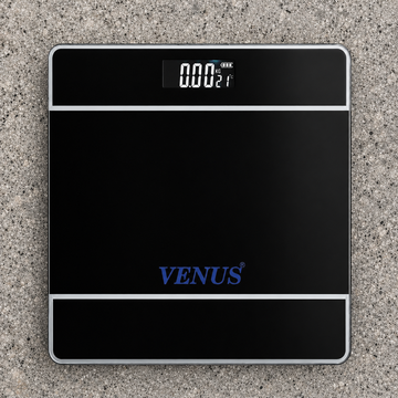 Digital bathroom weighing scale with tempered glass platform on a tiled bathroom floor.