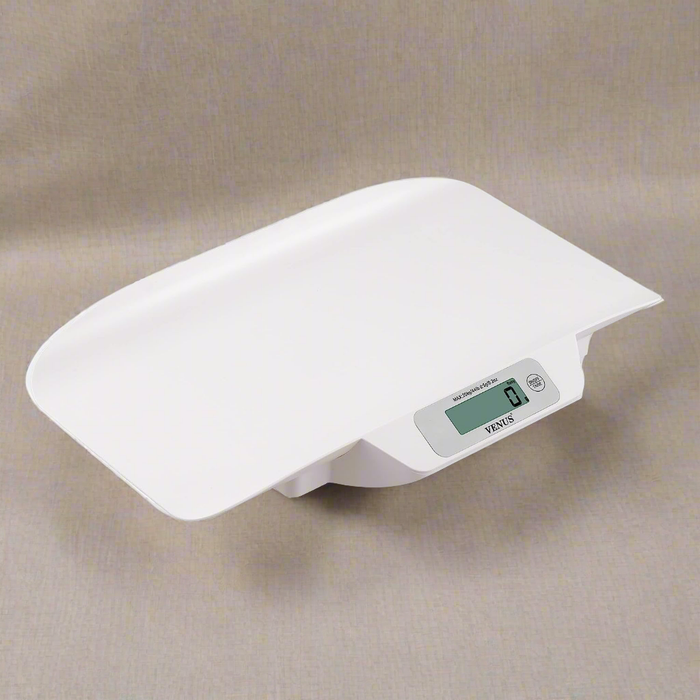 A baby weighing scale with tray showing 0g on green LED display